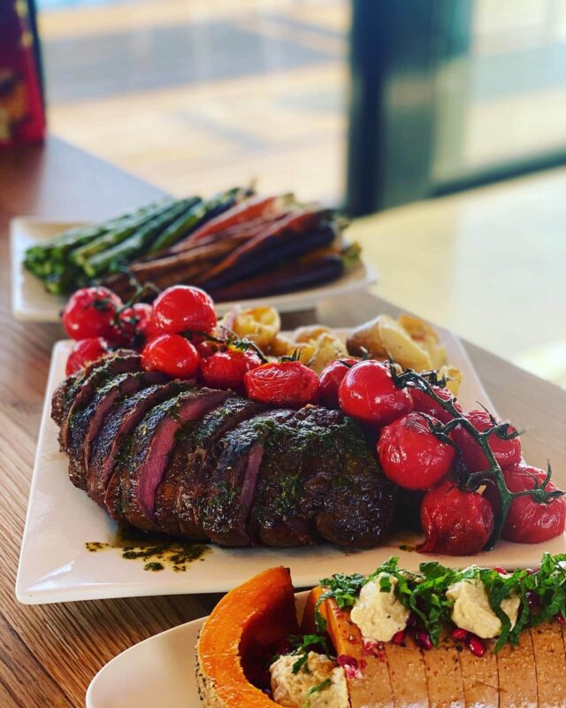 A platter of roast beef with grilled tomatoes