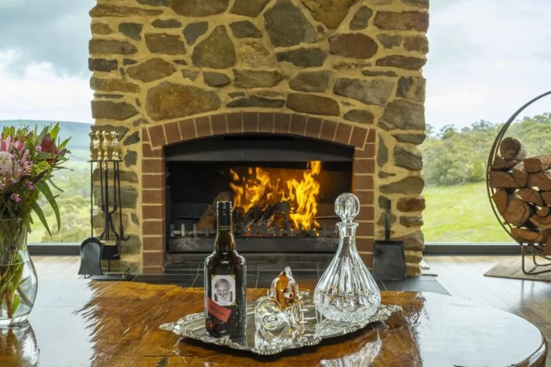 Open fireplace with flames. Port and decanter