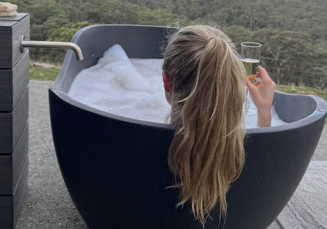 Luxurious outdoor bubble bath overlooking native Australian bush.